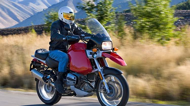 A rider takes his motorcycle dothe road.